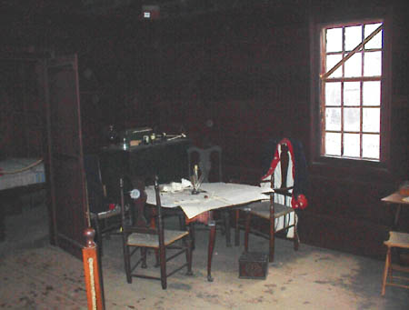 Table laid with maps and revolutionary war officers coat.